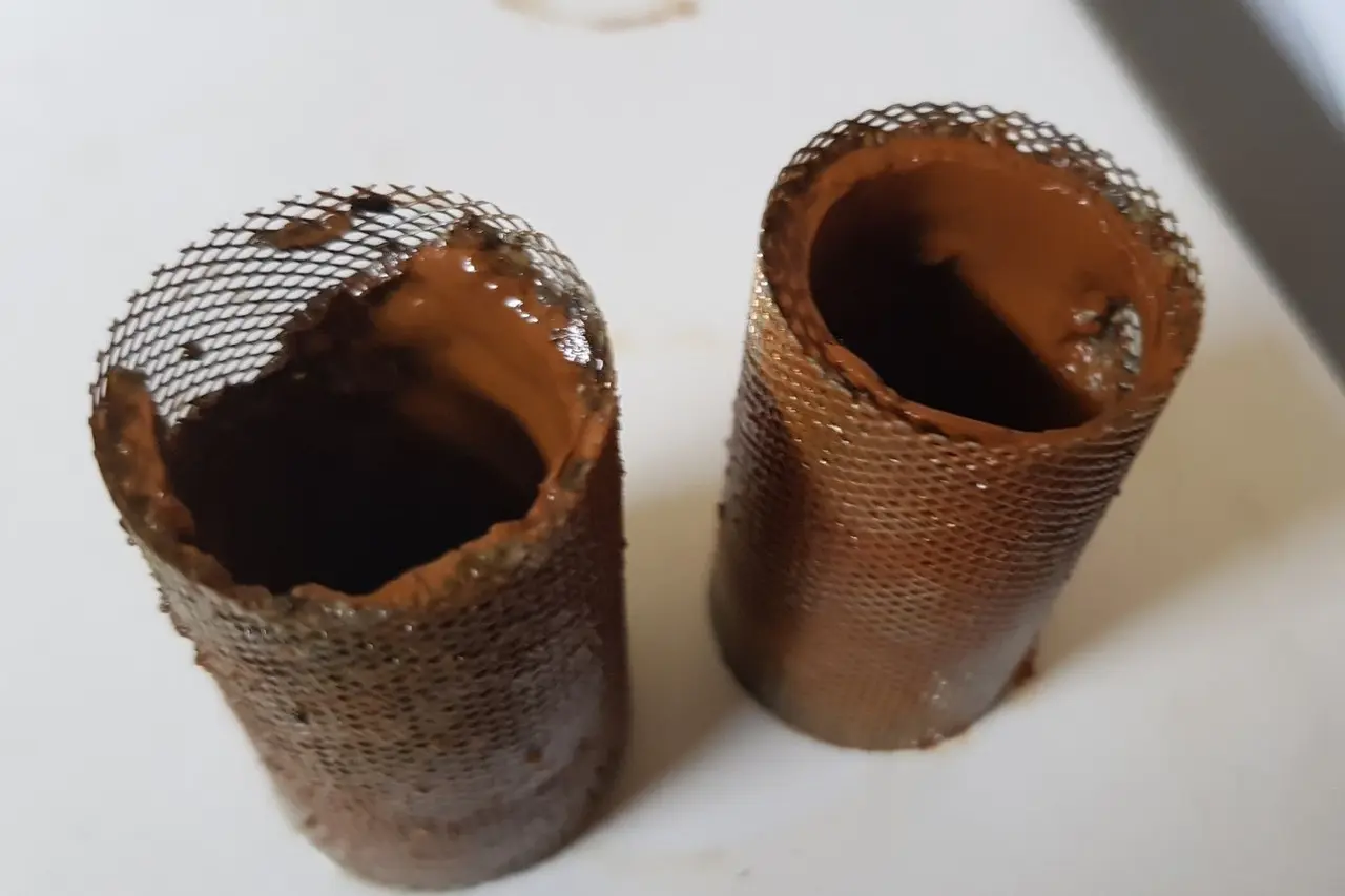 Dvě sítka filtrů zanesená kalem z otopné soustavy